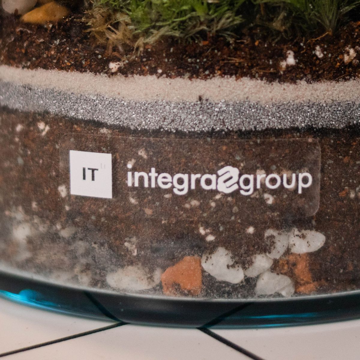 Slika prikazuje personalizirani terarij s prozirnom naljepnicom za tvrtku Integra group.